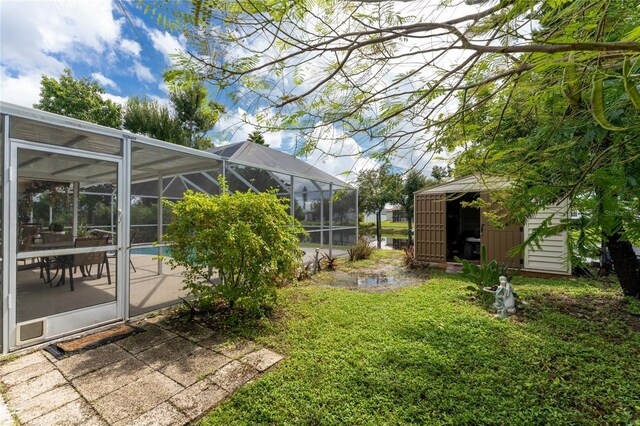 13511 Foresman Blvd, Port Charlotte, FL 33981 - view of yard featuring an outdoor pool, an outdoor structure, a patio, a storage unit, and a lanai
