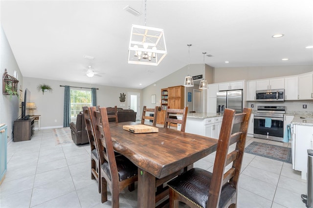 dining area with lofted ceiling, light tile patterned flooring, and ceiling fan