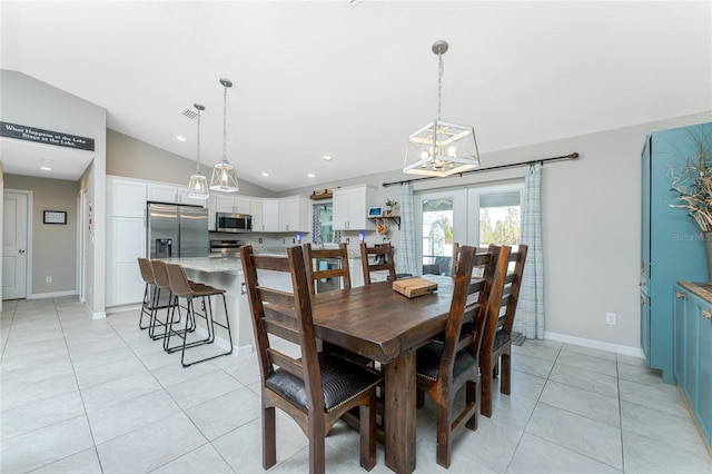 tiled dining space featuring french doors and vaulted ceiling