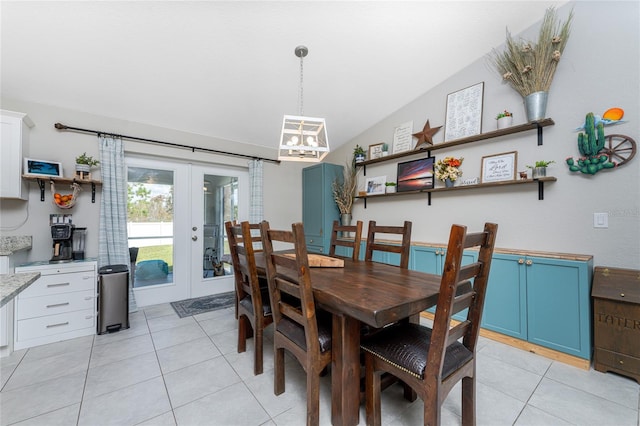 tiled dining room featuring lofted ceiling and french doors