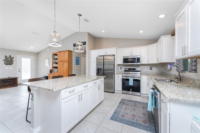 kitchen with a kitchen island, stainless steel appliances, sink, vaulted ceiling, and white cabinetry