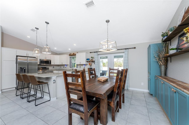 dining area with lofted ceiling, a notable chandelier, light tile patterned flooring, french doors, and sink