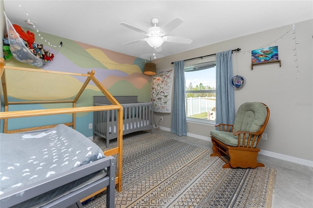 bedroom with a crib, concrete flooring, and ceiling fan