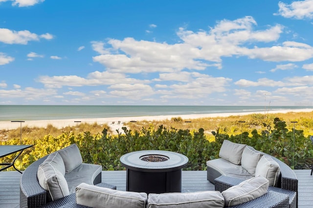 deck with a water view, a view of the beach, and an outdoor hangout area