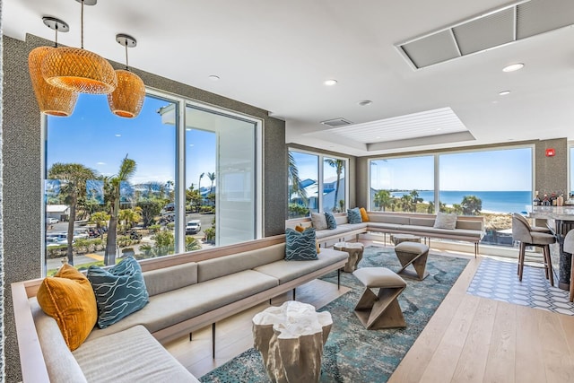 living room featuring hardwood / wood-style floors, a water view, and plenty of natural light