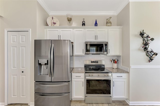 kitchen featuring appliances with stainless steel finishes, white cabinets, and light stone countertops