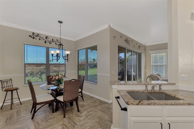 dining space with an inviting chandelier, light parquet flooring, sink, and crown molding