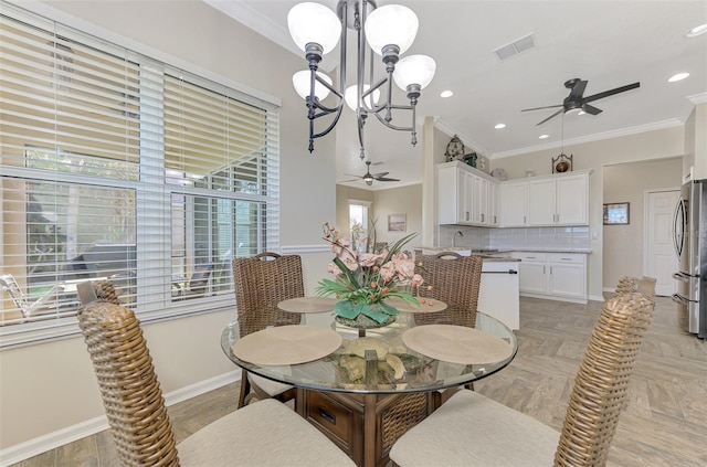 dining space with ornamental molding, light parquet floors, and ceiling fan with notable chandelier