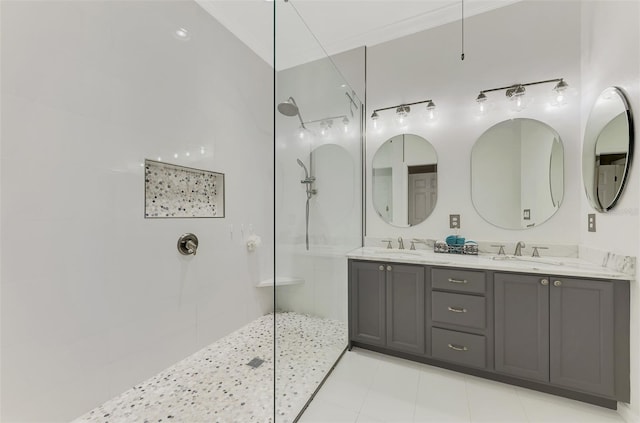 bathroom featuring vanity, a tile shower, and tile patterned flooring