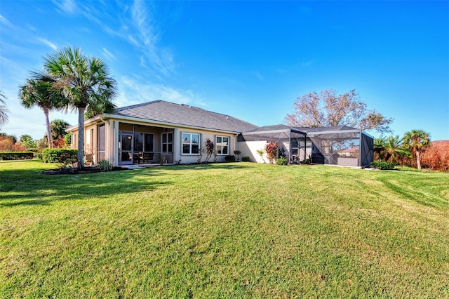 rear view of property with a yard and a lanai