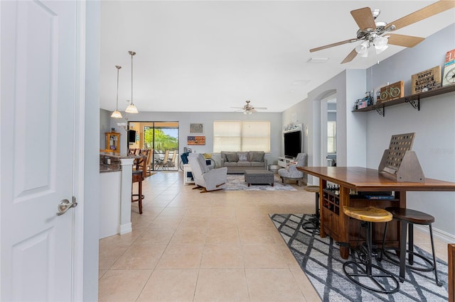 tiled dining space with ceiling fan