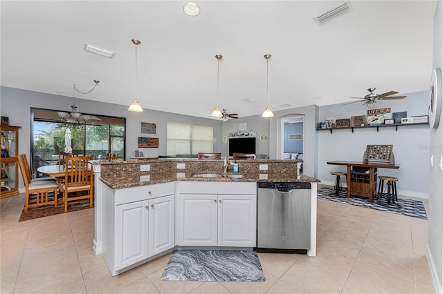 kitchen with white cabinets, hanging light fixtures, sink, stainless steel dishwasher, and dark stone counters