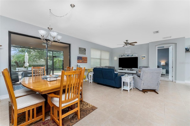 tiled dining room with ceiling fan with notable chandelier