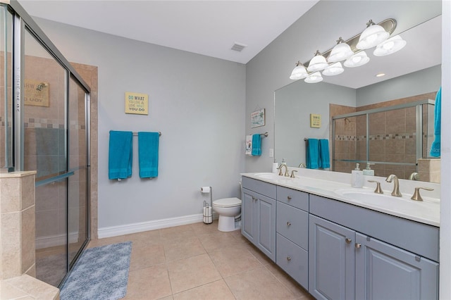 bathroom with tile patterned floors, an enclosed shower, vanity, and toilet