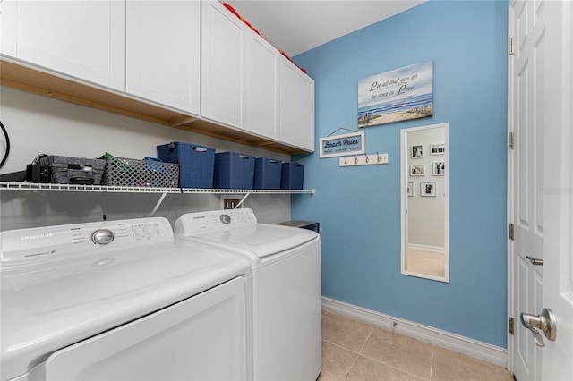 washroom featuring cabinets, light tile patterned floors, and washing machine and dryer