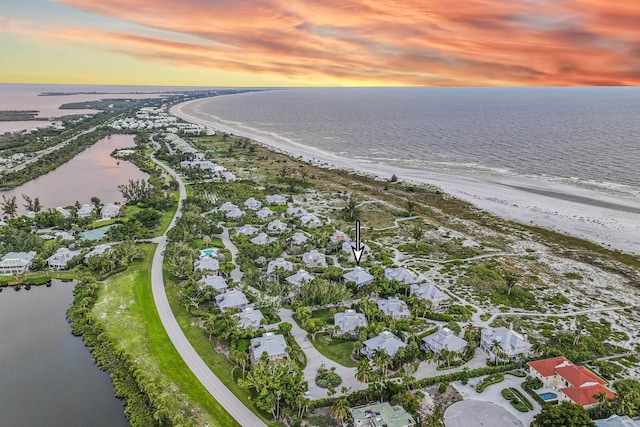 aerial view at dusk featuring a water view