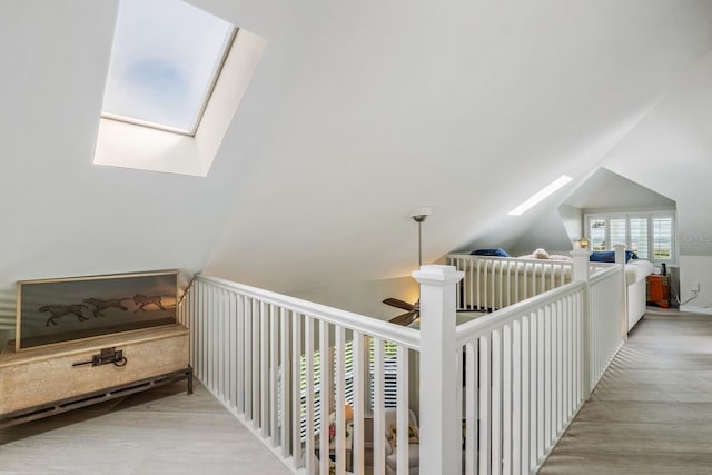 hallway featuring vaulted ceiling with skylight