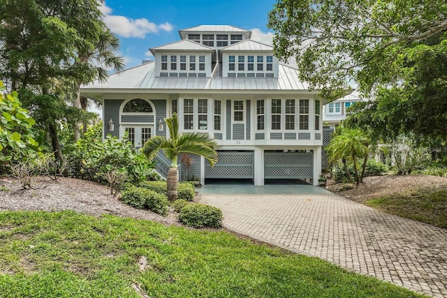 22 Seawatch Dr, Boca Grande, FL 33921 - coastal inspired home with a carport, decorative driveway, a metal roof, and a standing seam roof