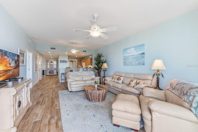 living room featuring ceiling fan and light hardwood / wood-style floors