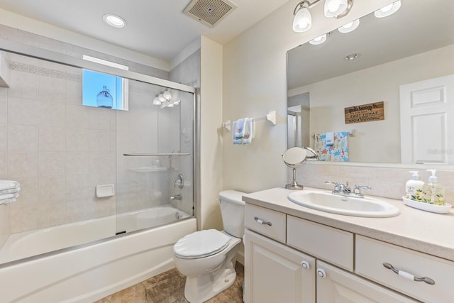 full bathroom with vanity, combined bath / shower with glass door, and toilet