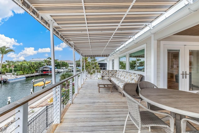 wooden terrace featuring an outdoor living space, french doors, and a water view