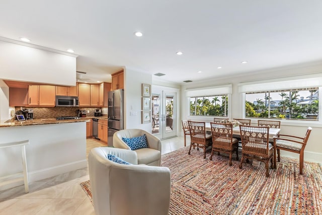 tiled dining area with ornamental molding and french doors