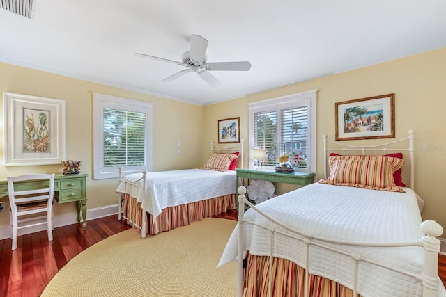 bedroom featuring multiple windows, ceiling fan, dark wood-type flooring, and ornamental molding