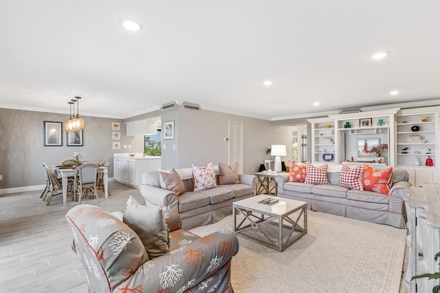 living room featuring light wood-type flooring, an inviting chandelier, and ornamental molding