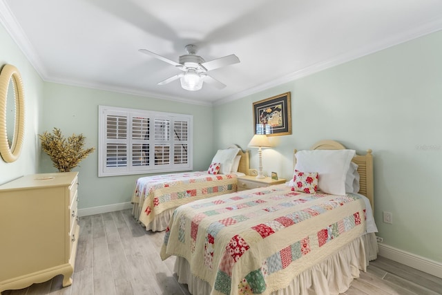 bedroom featuring light hardwood / wood-style flooring, ceiling fan, and crown molding