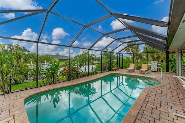 view of pool with a patio and glass enclosure