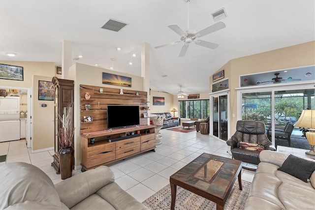 living room featuring light tile patterned flooring, lofted ceiling, and stacked washer and clothes dryer