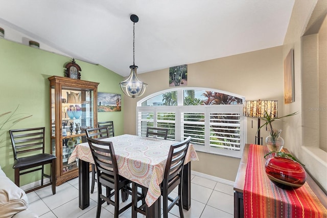 tiled dining area featuring lofted ceiling and a chandelier