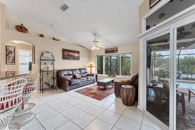 living room featuring ceiling fan, light tile patterned floors, and vaulted ceiling