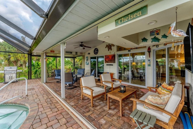 view of patio featuring a lanai, area for grilling, ceiling fan, and outdoor lounge area