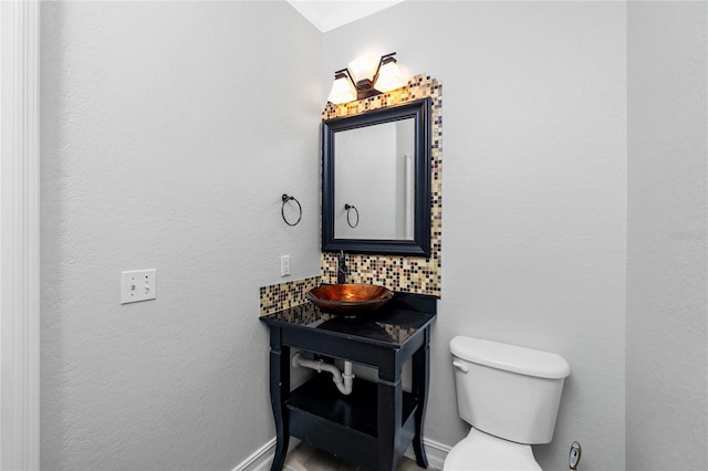 bathroom featuring vanity, toilet, ornamental molding, and tasteful backsplash