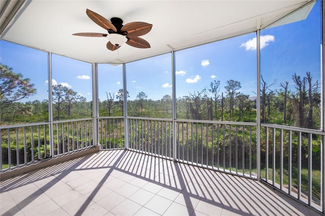 unfurnished sunroom featuring ceiling fan and a wealth of natural light