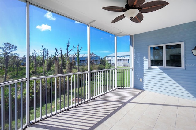 unfurnished sunroom featuring ceiling fan