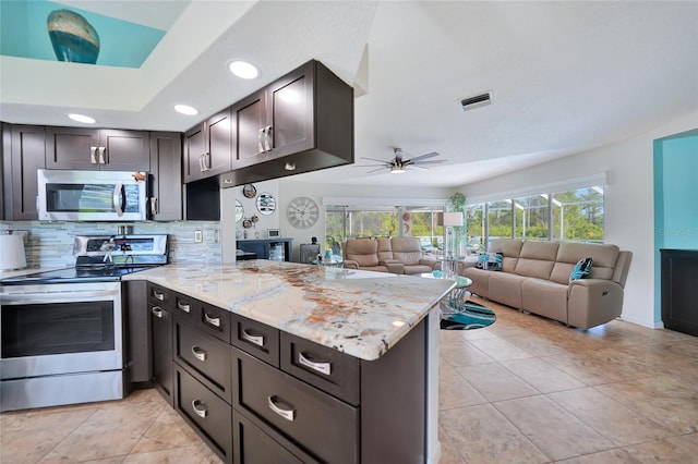 kitchen featuring a wealth of natural light, appliances with stainless steel finishes, and kitchen peninsula