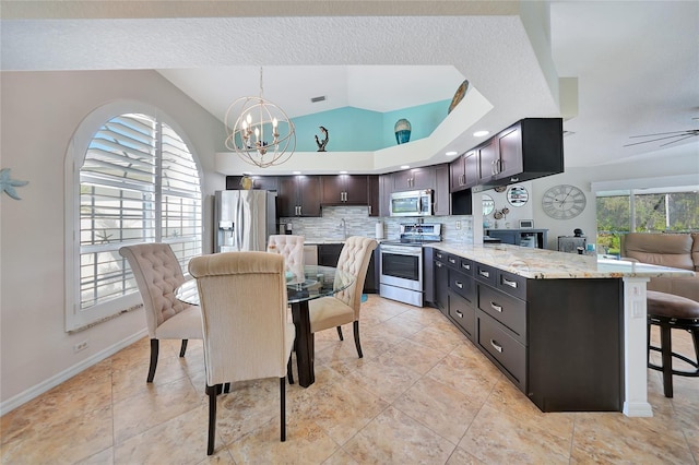 kitchen with tasteful backsplash, dark brown cabinets, a breakfast bar area, appliances with stainless steel finishes, and vaulted ceiling