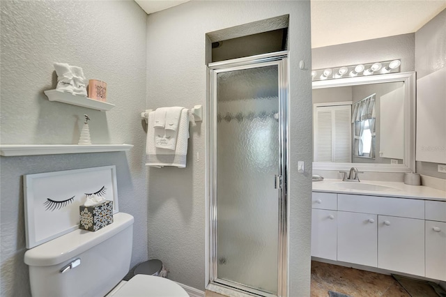 bathroom featuring vanity, a shower with shower door, and toilet