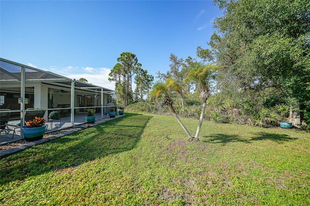 view of yard featuring a patio and glass enclosure