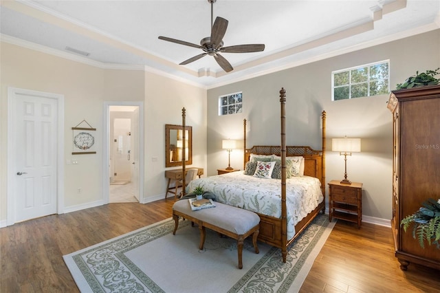 bedroom featuring ornamental molding, hardwood / wood-style floors, ensuite bathroom, and ceiling fan