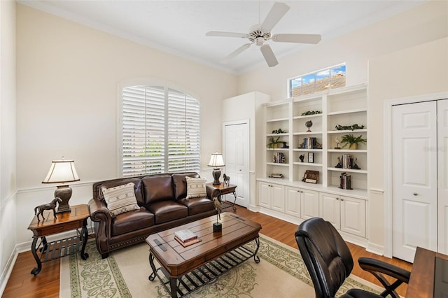 living room featuring crown molding, light hardwood / wood-style flooring, and ceiling fan