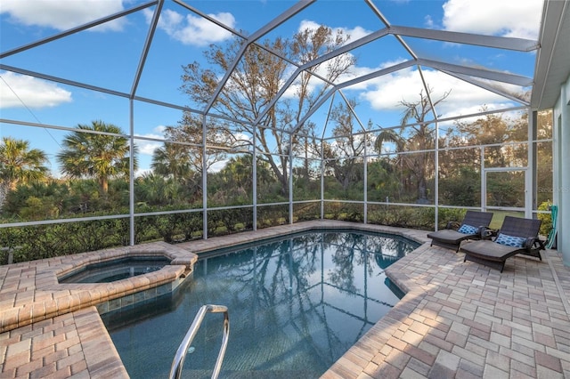 view of swimming pool featuring an in ground hot tub, a patio area, and a lanai