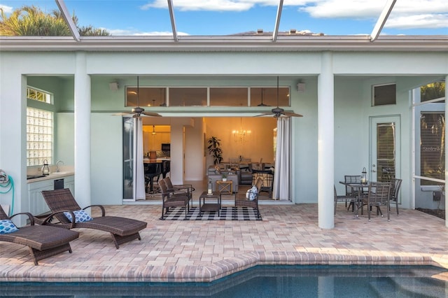 rear view of house featuring a patio, glass enclosure, and ceiling fan