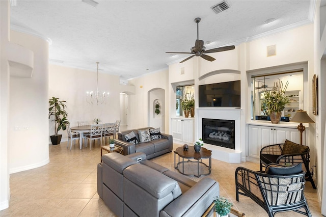 tiled living room with ornamental molding, a textured ceiling, and ceiling fan with notable chandelier