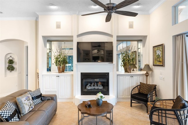 tiled living room with a towering ceiling, crown molding, a textured ceiling, and ceiling fan