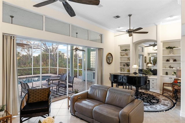 living room with crown molding, ceiling fan, built in shelves, and light tile patterned floors