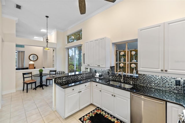 kitchen featuring tasteful backsplash, hanging light fixtures, white cabinetry, stainless steel dishwasher, and sink