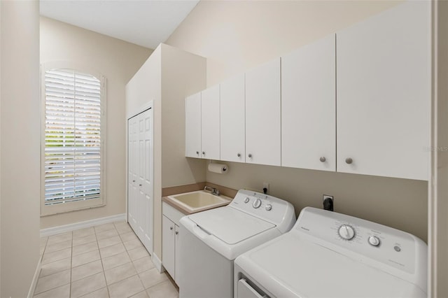 laundry area with sink, washer and clothes dryer, light tile patterned flooring, and cabinets